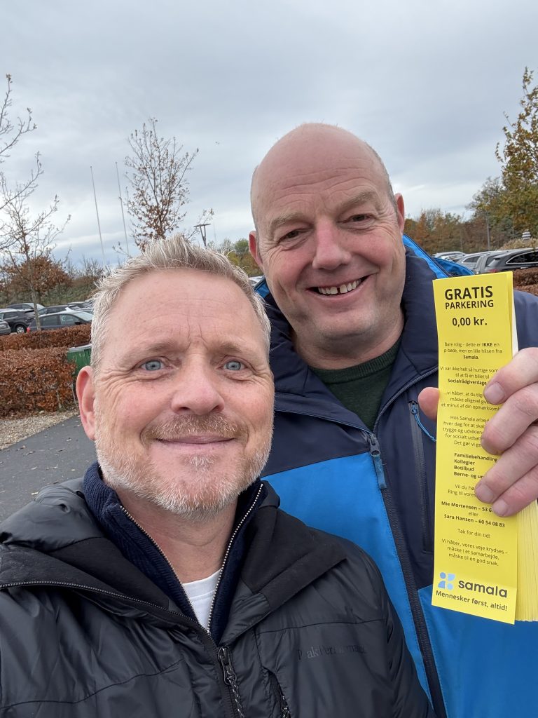 to mænd udenfor, smiler, med p-bøde