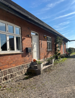 rødt hus med hvid dør og hvide vinduer